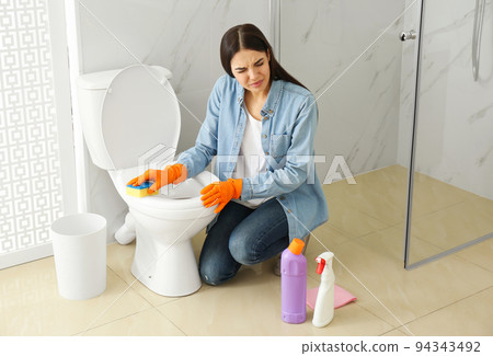 Young woman feeling disgust while cleaning Young woman feeling disgust while cleaning 94343492