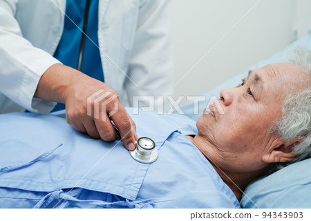 Asia doctor with stethoscope checking elderly woman patient in hospital, healthy medical concept. 94343903