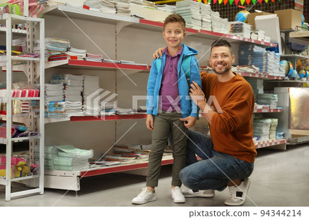 Little boy and father near shelves with school stationery in store 94344214