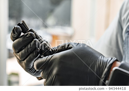 The gunsmith maintaining his rifle in a workshop The gunsmith maintaining his rifle in a workshop 94344418