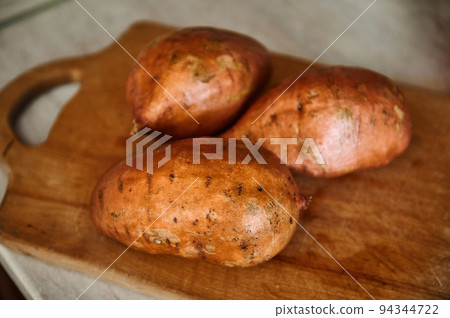 Raw whole sweet potato or batatas on old wooden cutting board. Batatas on wooden surface. Healthy food. Raw organic batatas tubers. Healthy dieting food enriched in minerals and vitamins. Veganism Raw whole sweet potato or batatas on old wooden cutting board. Batatas on wooden surface. Healthy food. Raw organic batatas tubers. Healthy dieting food enriched in minerals and vitamins. Veganism 94344722