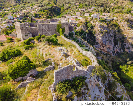 Old city. Sunny view of ruins of citadel in Stari Bar town near Bar city, Montenegro. Drone view Portrait of a disgruntled girl sitting at a cafe table 94345183