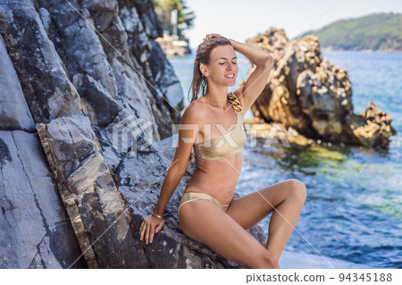 Beautiful emotional Model Girl against the backdrop of the sea and beautiful rocks. Beautiful Woman enjoying the Waves of the Ocean. vacation. Mediterranean Sea 94345188