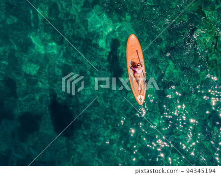 Young women Having Fun Stand Up Paddling in blue water sea in Montenegro. SUP. girl Training on Paddle Board near the rocks Portrait of a disgruntled girl sitting at a cafe table Young women Having Fun Stand Up Paddling in blue water sea in Montenegro. SUP. girl Training on Paddle Board near the rocks Portrait of a disgruntled girl sitting at a cafe table 94345194