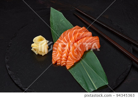 Japanese food style, Top view of salmon slice on bamboo leaves, Salmon sashimi is Japanese traditional, Selective focus, Fish slices top view Japanese food style, Top view of salmon slice on bamboo leaves, Salmon sashimi is Japanese traditional, Selective focus, Fish slices top view 94345363
