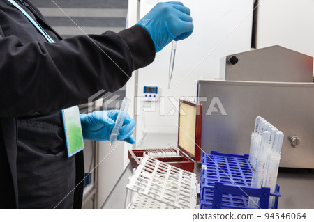 Female scientist preparing slides for karyotipe and fluorescence in situ hybridization at the laboratory 94346064
