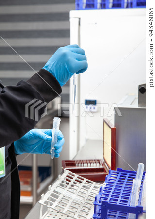Female scientist preparing slides for karyotipe and fluorescence in situ hybridization at the laboratory 94346065