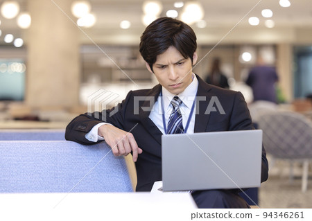 A businessman operating a laptop computer 94346261