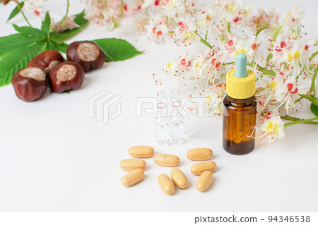 Bottle of horse chestnut extract, essence of chestnut flowers. Flowering branches and leaves of horse chestnut. Bottle of horse chestnut extract, essence of chestnut flowers. Flowering branches and leaves of horse chestnut. 94346538