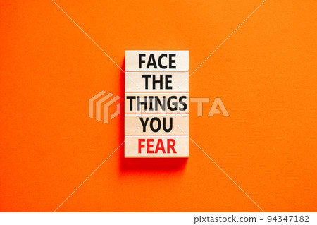 Face the things you fear symbol. Concept words Face the things you fear on wooden blocks on a beautiful orange table orange background. Business and face the things you fear concept. Copy space. 94347182