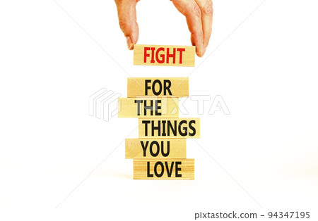 Fight for love symbol. Concept words Fight for the things you love on wooden blocks on a beautiful white table white background. Businessman hand. Business motivational and fight for love concept. Fight for love symbol. Concept words Fight for the things you love on wooden blocks on a beautiful white table white background. Businessman hand. Business motivational and fight for love concept. 94347195