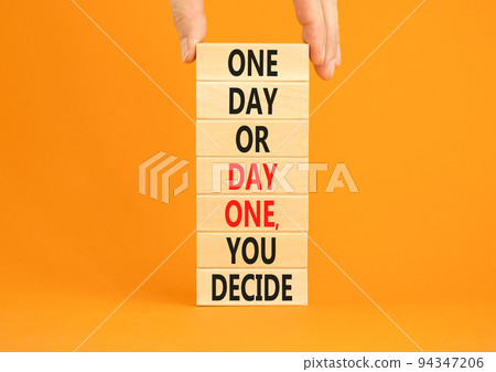 Day one symbol. Concept words One day or day one you decide on wooden blocks on a beautiful orange table orange background. Businessman hand. Business motivational and day one concept. Day one symbol. Concept words One day or day one you decide on wooden blocks on a beautiful orange table orange background. Businessman hand. Business motivational and day one concept. 94347206