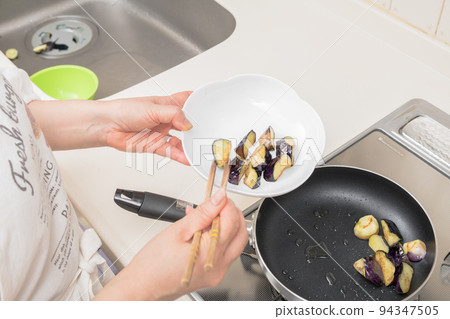 [Make the eggplant deep-fried in soy sauce. Put the fried eggplant on a plate] 94347505