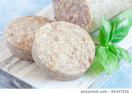 Traditional Irish white or oatmeal pudding sausage slices on a wooden board, horizontal, closeup Traditional Irish white or oatmeal pudding sausage slices on a wooden board, horizontal, closeup 94347938