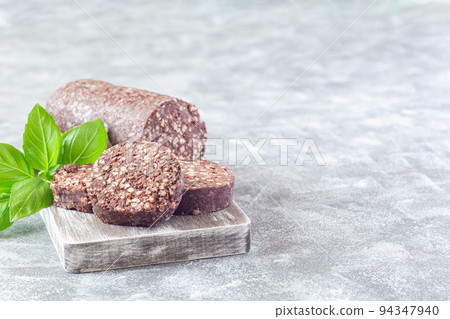 Traditional Irish and British black pudding sausage slices on a wooden board, horizontal, copy space Traditional Irish and British black pudding sausage slices on a wooden board, horizontal, copy space 94347940