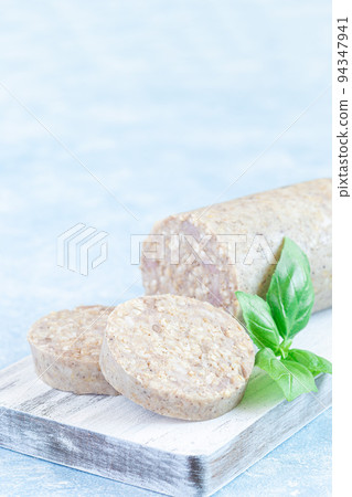 Traditional Irish white or oatmeal pudding sausage slices on a wooden board, vertical, copy space 94347941