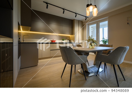 Modern grey luxurious kitchen with dining table in studio apartment 94348089