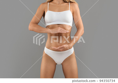 Sporty Female In Underwear Holding Invisible Object Near Her Flat Belly 94350734