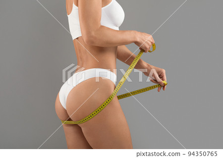 Unrecognizable Woman In Underwear With Measuring Tape Checking Her Hips Size Unrecognizable Woman In Underwear With Measuring Tape Checking Her Hips Size 94350765