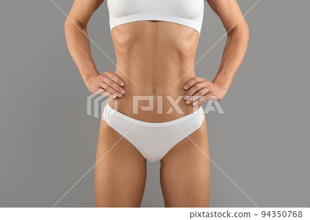Slim Female With Perfect Body In White Underwear Standing Over Grey Background Slim Female With Perfect Body In White Underwear Standing Over Grey Background 94350768