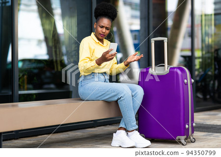 Displeased African American Woman Tourist Using Smartphone Having Problem Outside 94350799