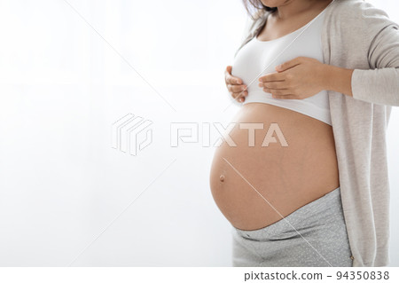 Unrecognizable pregnant woman having painful feelings in breast, copy space 94350838