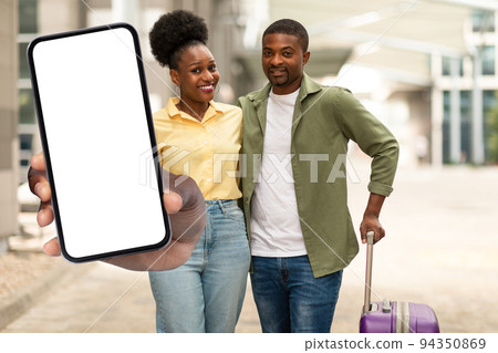 African American Tourists Couple Showing Huge Cellphone Screen At Airport 94350869