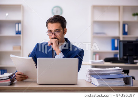 Young male employee working in the office Young male employee working in the office 94356197