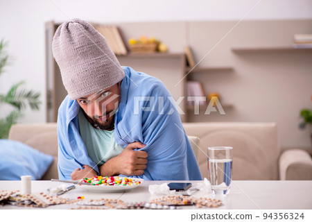 Young sick man suffering at home Young sick man suffering at home 94356324