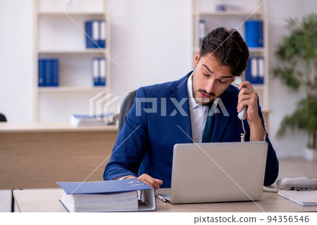 Young male employee working in the office Young male employee working in the office 94356546