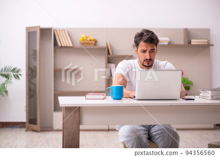 Young male employee working from home during pandemic 94356560