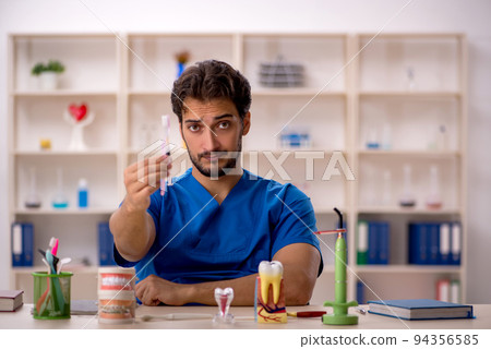 Young male dentist working in the clinic 94356585