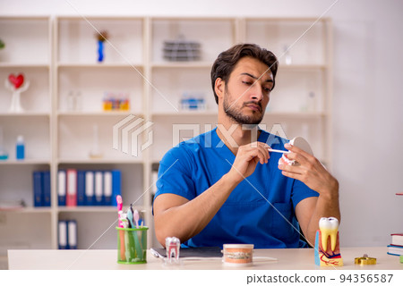 Young male dentist working in the clinic 94356587