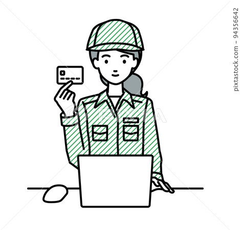 A female worker sitting at a desk and using a PC while holding a credit card A female worker sitting at a desk and using a PC while holding a credit card 94356642