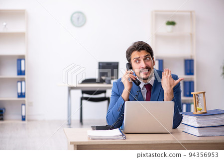 Young male employee in time management concept 94356953