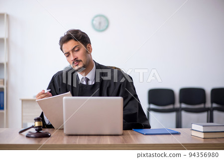 Young male judge working in the courthouse 94356980