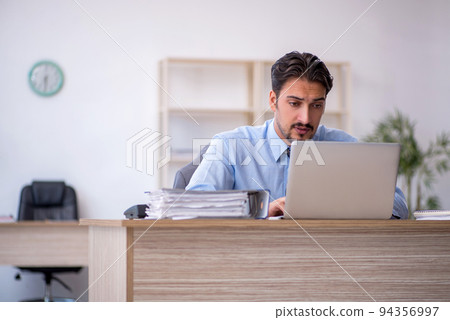 Young male employee working in the office Young male employee working in the office 94356997