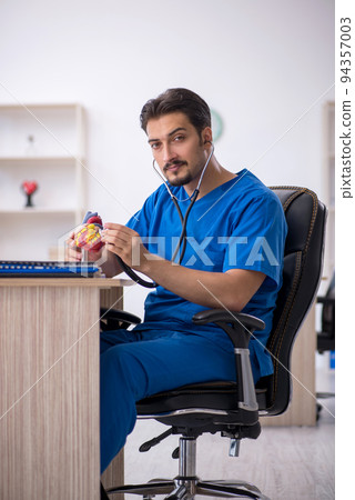 Young male doctor cardiologist working in the clinic 94357003