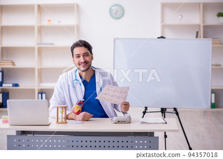 Young male doctor cardiologist in time management concept 94357018