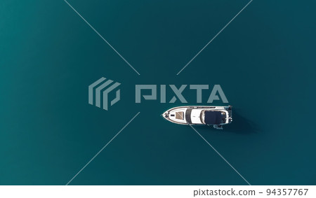 Aerial yacht on calm sea. Luxury cruise trip. View from above of white boat on deep blue water. Aerial view of rich yacht sailing sea. Summer journey on luxury ship. Aerial yacht on calm sea. Luxury cruise trip. View from above of white boat on deep blue water. Aerial view of rich yacht sailing sea. Summer journey on luxury ship. 94357767