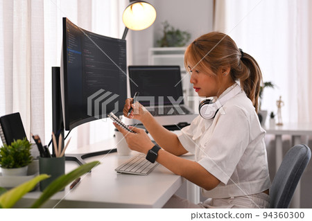 Young female programmer working on computer to check coding in bugging system in IT office Young female programmer working on computer to check coding in bugging system in IT office 94360300