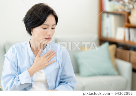 A woman who puts her hand on her chest in the living room 94362892