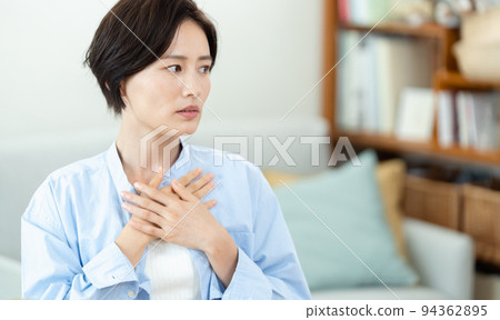在客廳裡把手放在胸前的女人 94362895