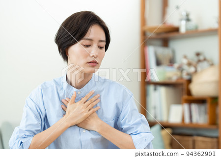 A woman who puts her hand on her chest in the living room 94362901