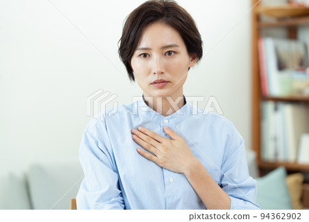 在客廳裡把手放在胸前的女人 94362902