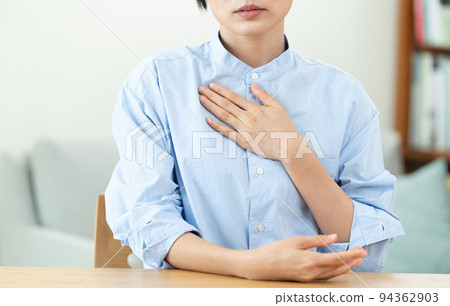 A woman who puts her hand on her chest in the living room 94362903