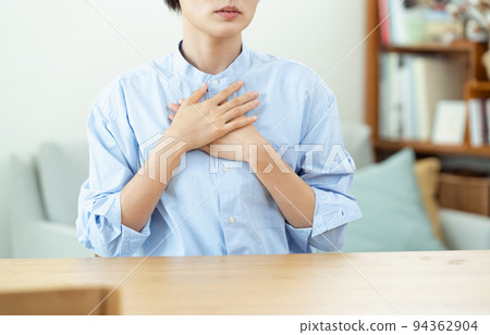 在客廳裡把手放在胸前的女人 94362904