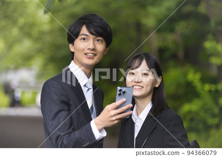 Men and women in recruitment suits looking at smartphones 94366079