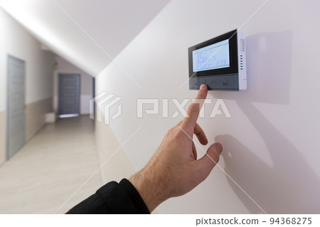 The air conditioning and heating control panel for the apartment and office is located on a white wall The air conditioning and heating control panel for the apartment and office is located on a white wall 94368275