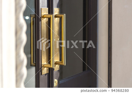 Door handle at the entrance to the restaurant, gold Door handle at the entrance to the restaurant, gold 94368280